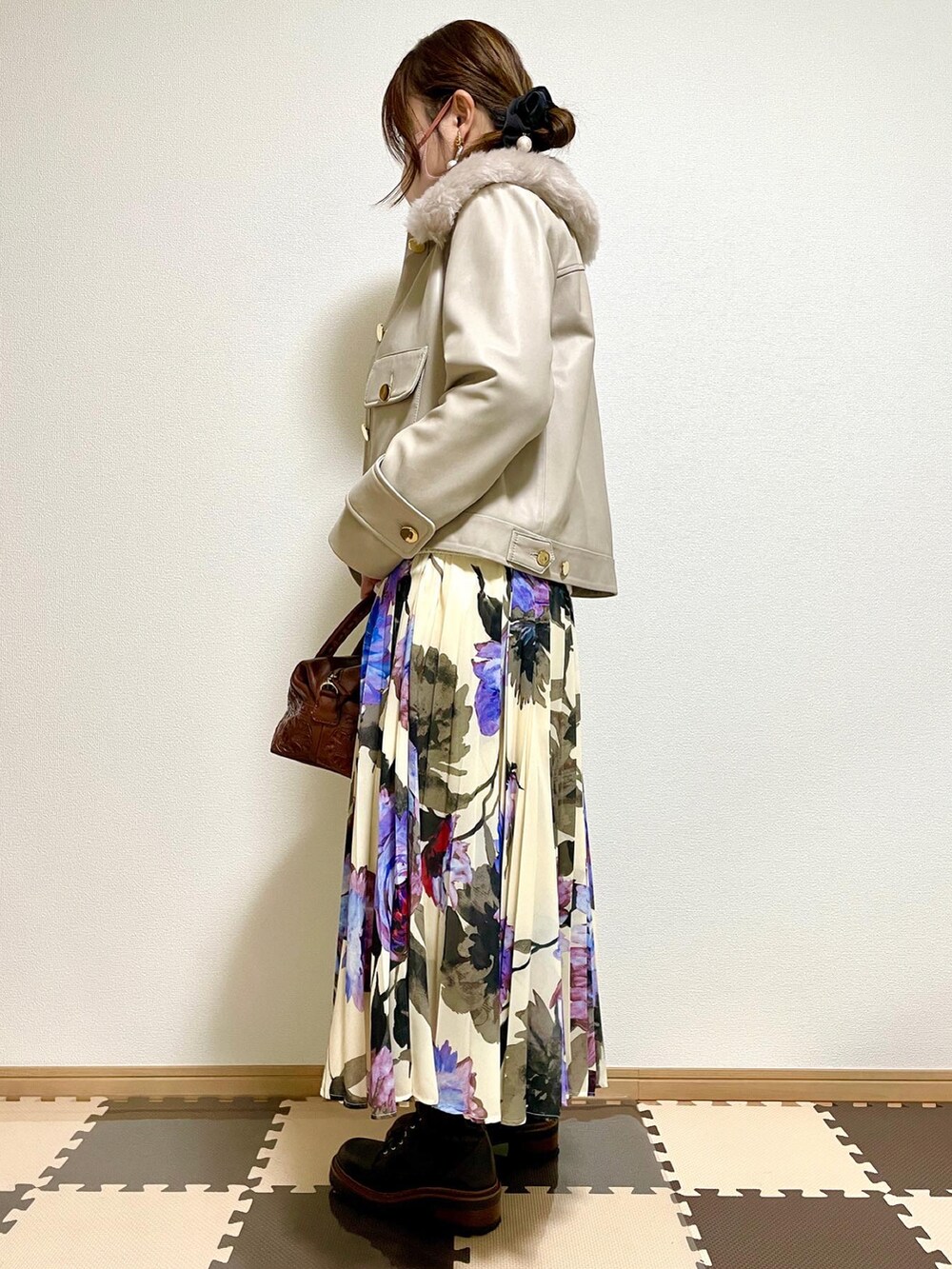 グレー系のダウンジャケット/コート、ホワイト系のニット/セーター、ブラウン系のボストンバッグを着用したレディースの秋コーディネートの2枚目の写真