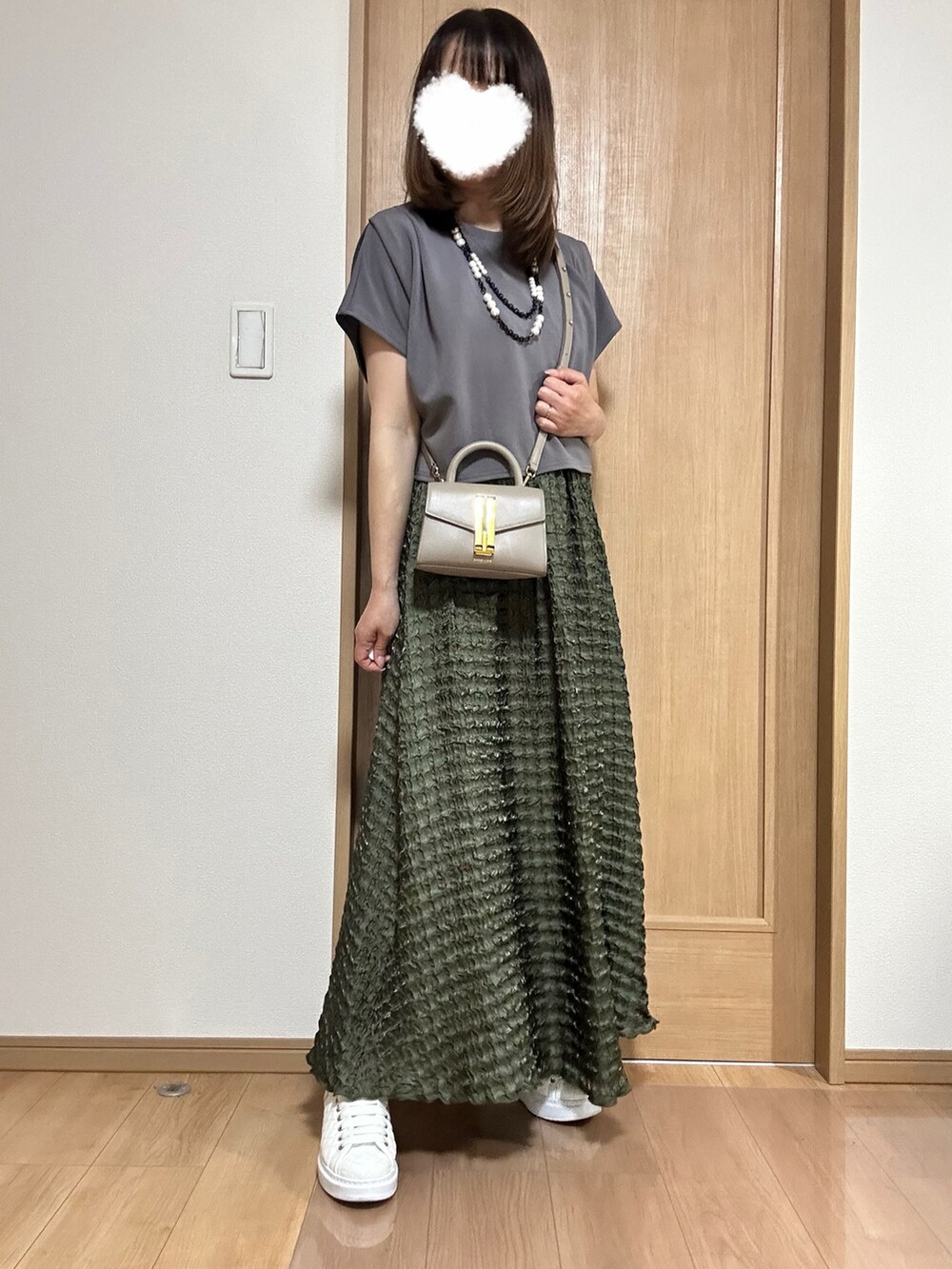 ホワイト系のカーディガン/ボレロ、グリーン系のワンピース、ホワイト系のスニーカーを着用したレディースの春コーディネートの5枚目の写真