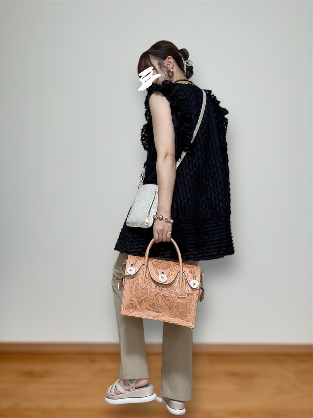 ベージュ系のハンドバッグ、ブラック系のトップス、ベージュ系のその他パンツを着用したレディースの秋コーディネートの2枚目の写真