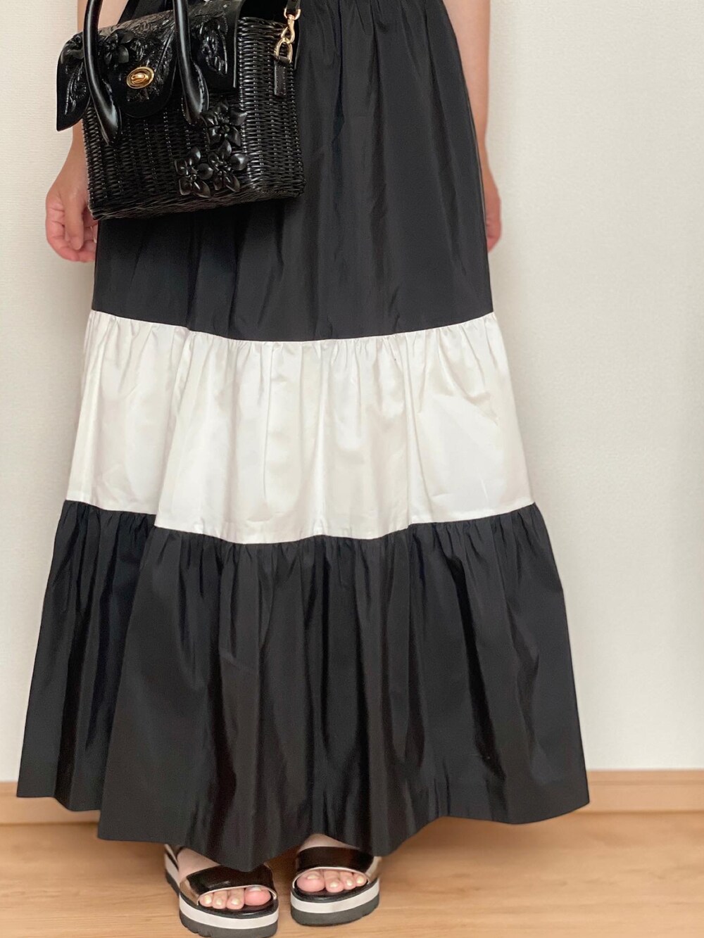 ホワイト系のシャツ/ブラウス、ブラック系のかごバッグ、ブラック系のスカートを着用したレディースの春コーディネートの4枚目の写真