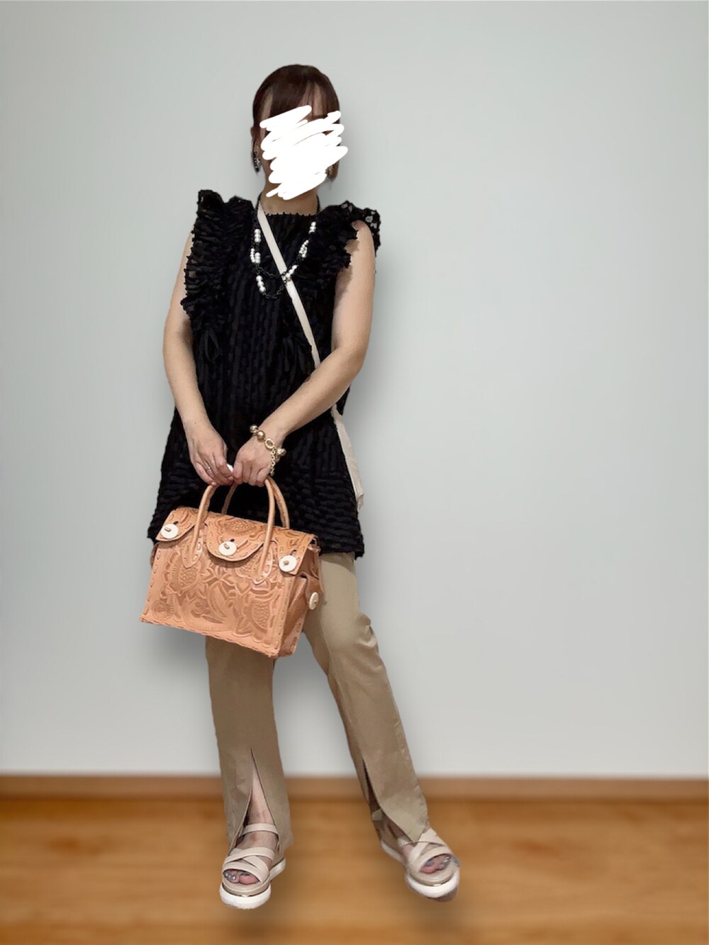 ベージュ系のハンドバッグ、ブラック系のトップス、ベージュ系のその他パンツを着用したレディースの秋コーディネートの4枚目の写真