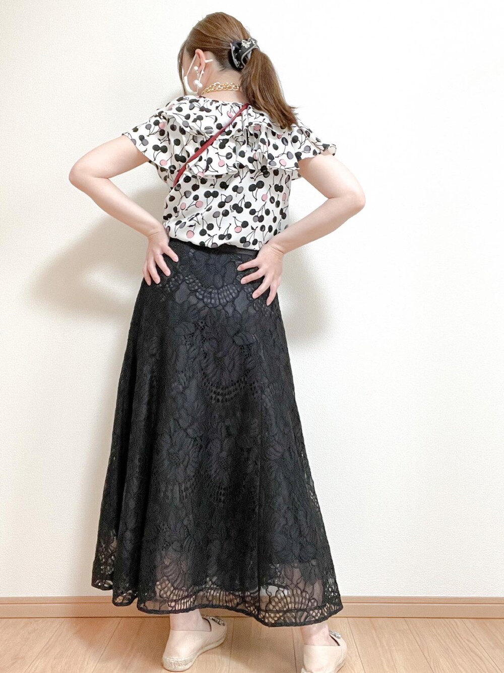 レッド系のバッグ、ベージュ系のスリッポン、ブラック系のスカートを着用したレディースの春コーディネートの3枚目の写真