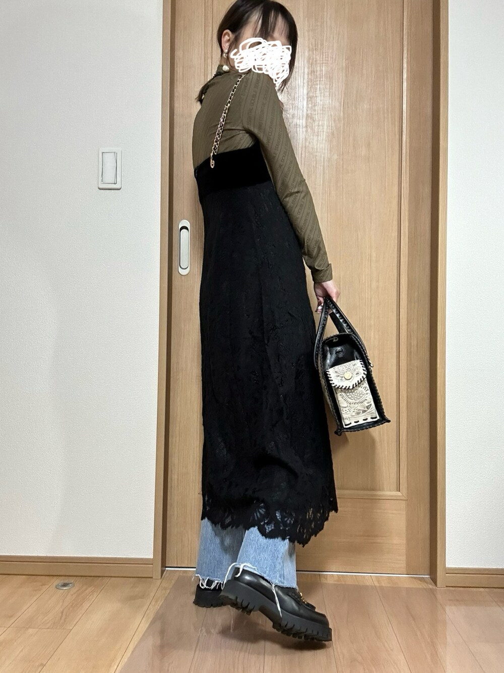 ブラック系のワンピース、ブラウン系のTシャツ/カットソー、ブラック系のバッグを着用したレディースの冬コーディネートの3枚目の写真