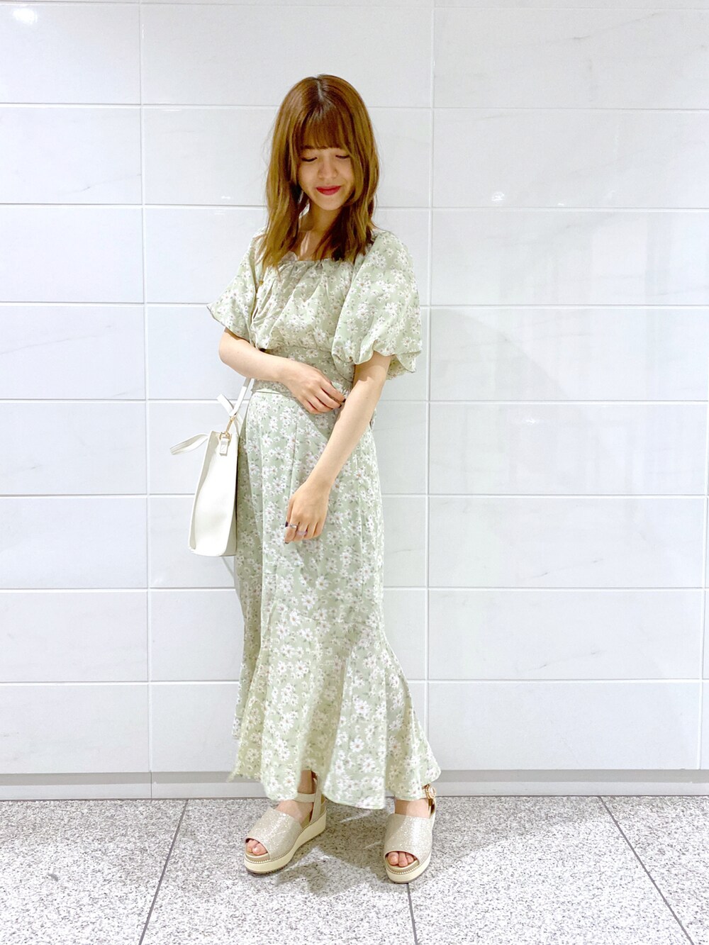グリーン系のシャツ/ブラウス、グリーン系のスカート、ホワイト系のサンダルを着用したレディースの春コーディネートの2枚目の写真