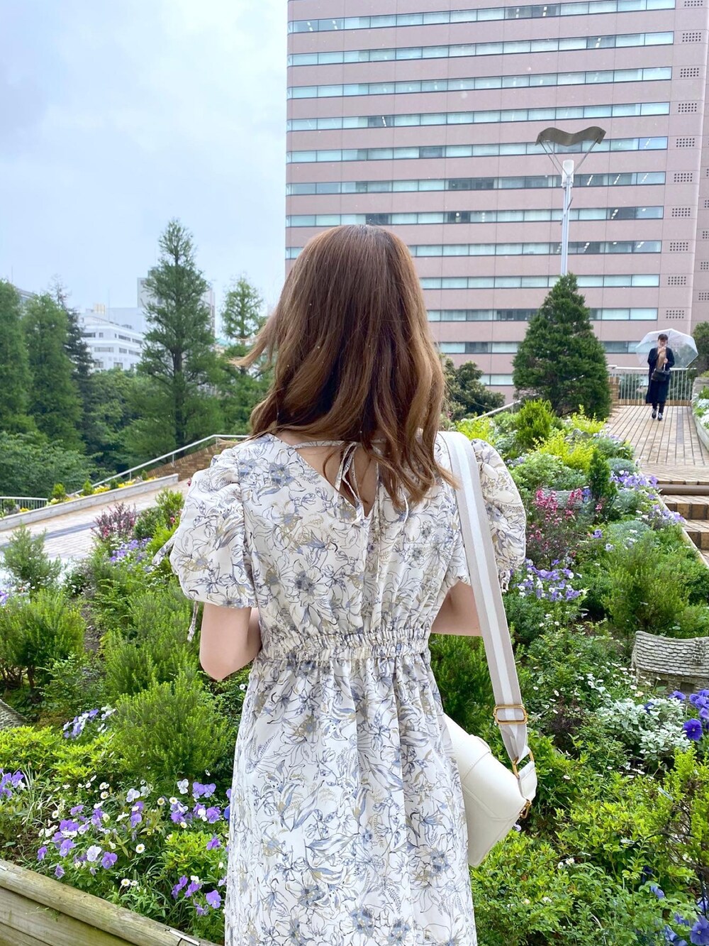 ホワイト系のサンダル、ベージュ系のワンピース、ホワイト系のショルダーバッグを着用したレディースの春コーディネートの2枚目の写真