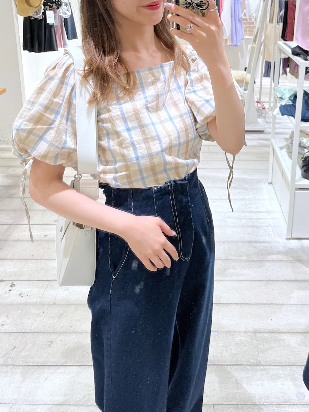 ブルー系のデニムパンツ、ベージュ系のシャツ/ブラウス、ブラック系のサンダルを着用したレディースの夏コーディネートの2枚目の写真