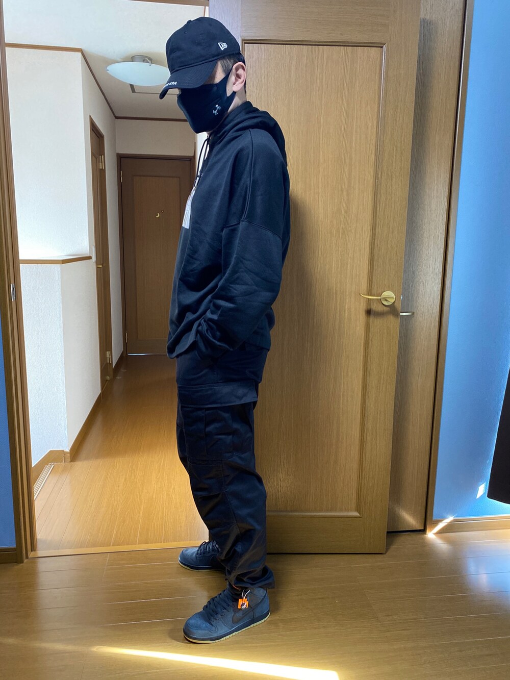 ブラック系のカーゴパンツ、ブラック系のスニーカー、ブラック系のパーカーを着用したメンズの秋コーディネートの2枚目の写真