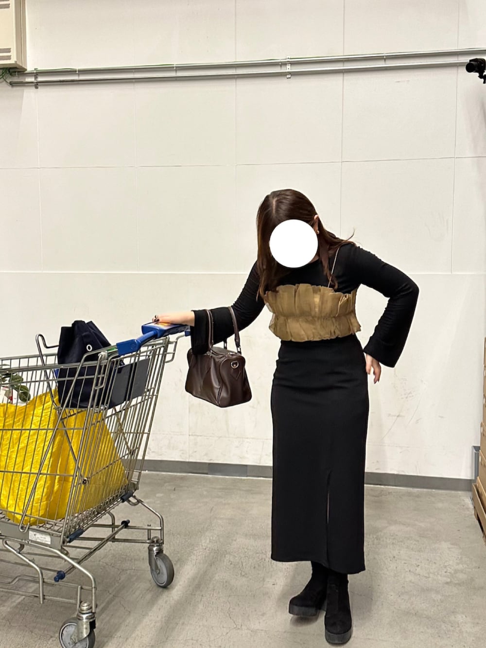 ベージュ系のTシャツ/カットソー、ブラック系のスカート、ブラック系のブーツを着用したレディースの秋コーディネートの2枚目の写真