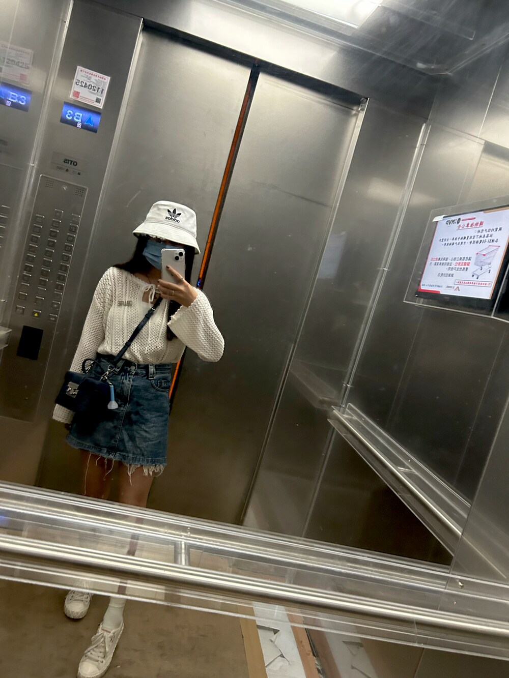 ブルー系のデニムスカート、ホワイト系のスニーカー、ホワイト系のカーディガン/ボレロを着用したレディースの夏コーディネートの2枚目の写真