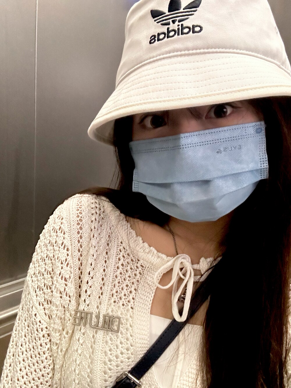 ブルー系のデニムスカート、ホワイト系のスニーカー、ホワイト系のカーディガン/ボレロを着用したレディースの夏コーディネートの3枚目の写真