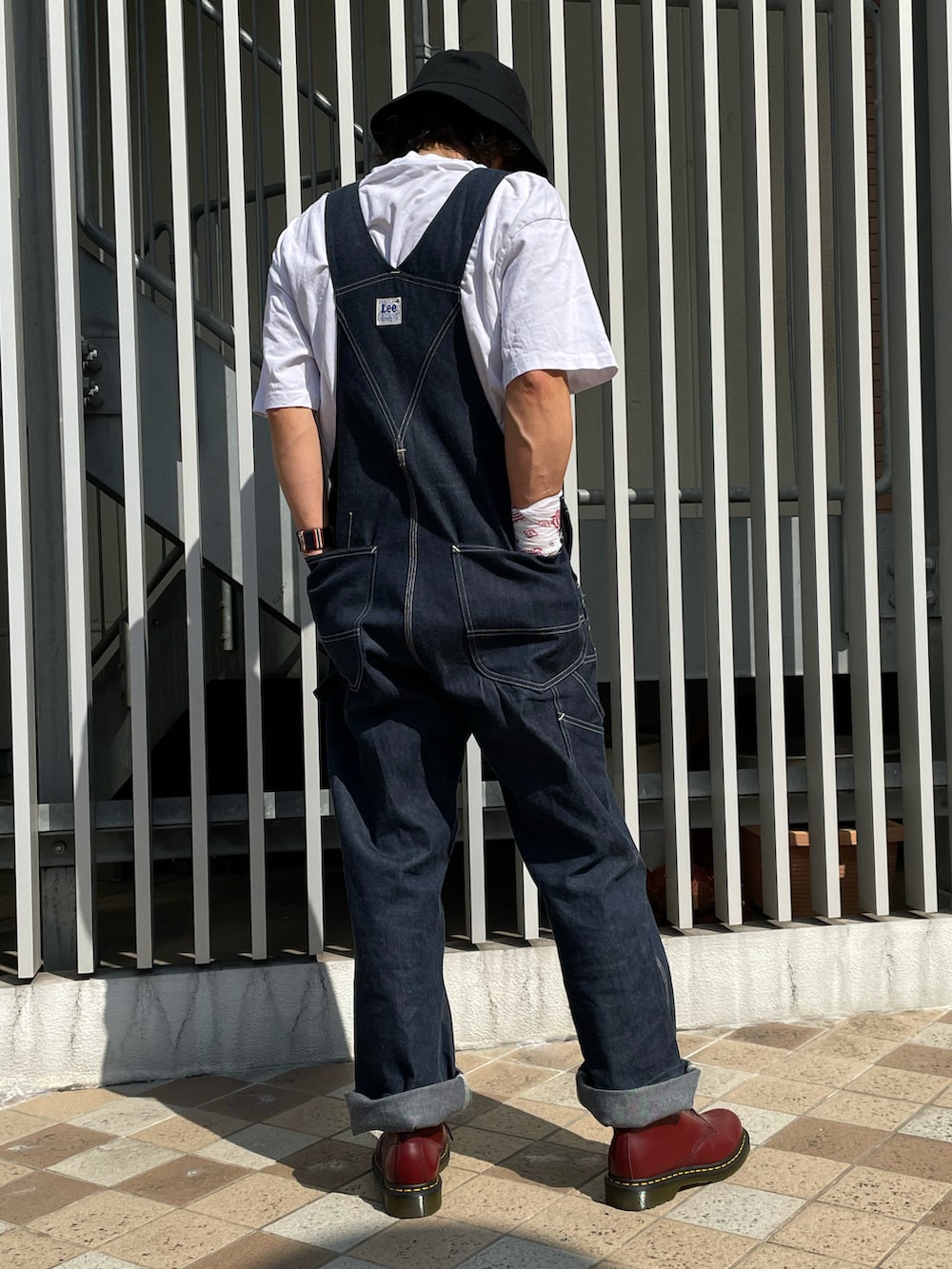 ブルー系のカバーオール、ブルー系のサロペット/オーバーオール、レッド系のブーツを着用したメンズの秋コーディネートの5枚目の写真
