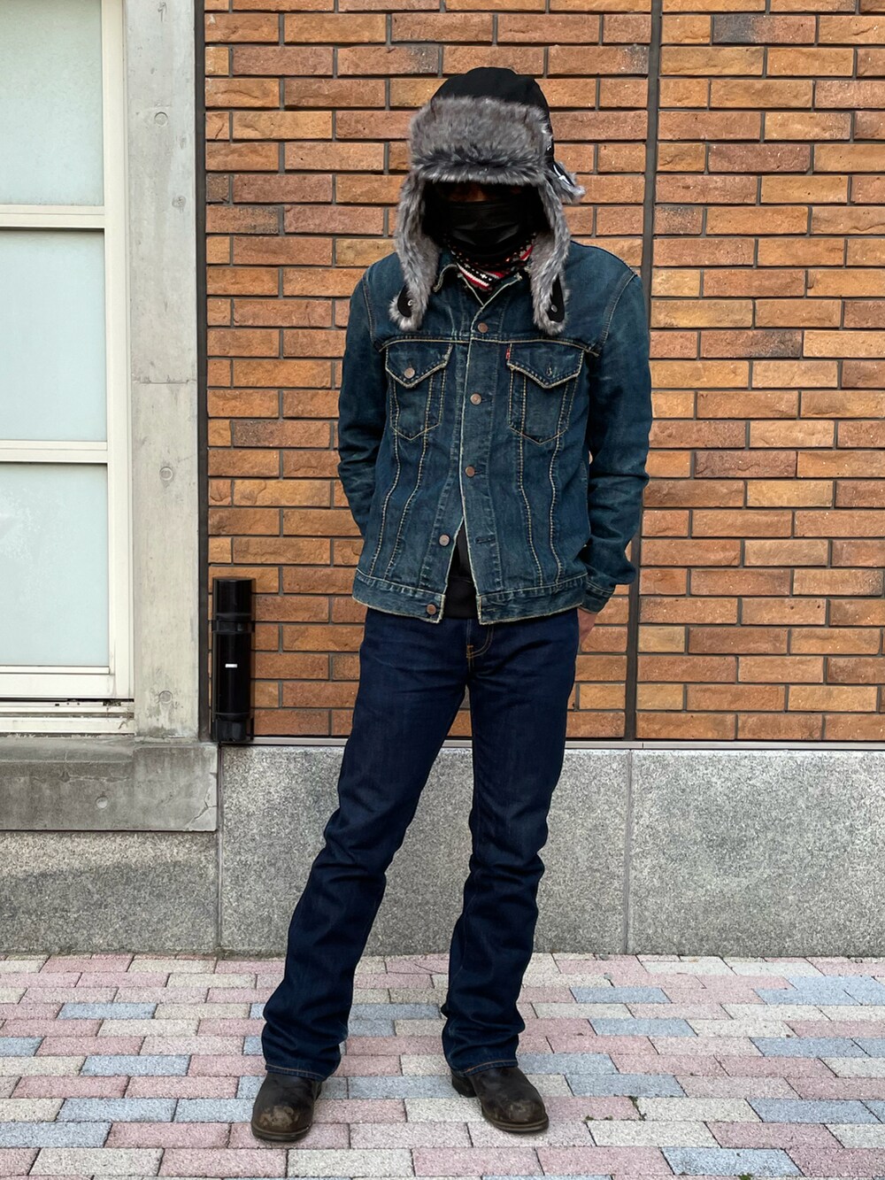 ブルー系のデニムパンツ、ブラック系のブーツ、ブラック系のスカジャンを着用したメンズの冬コーディネートの4枚目の写真