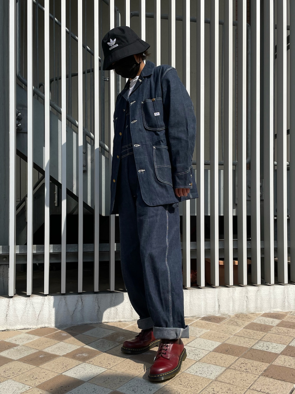 ブルー系のカバーオール、ブルー系のサロペット/オーバーオール、レッド系のブーツを着用したメンズの秋コーディネートの3枚目の写真