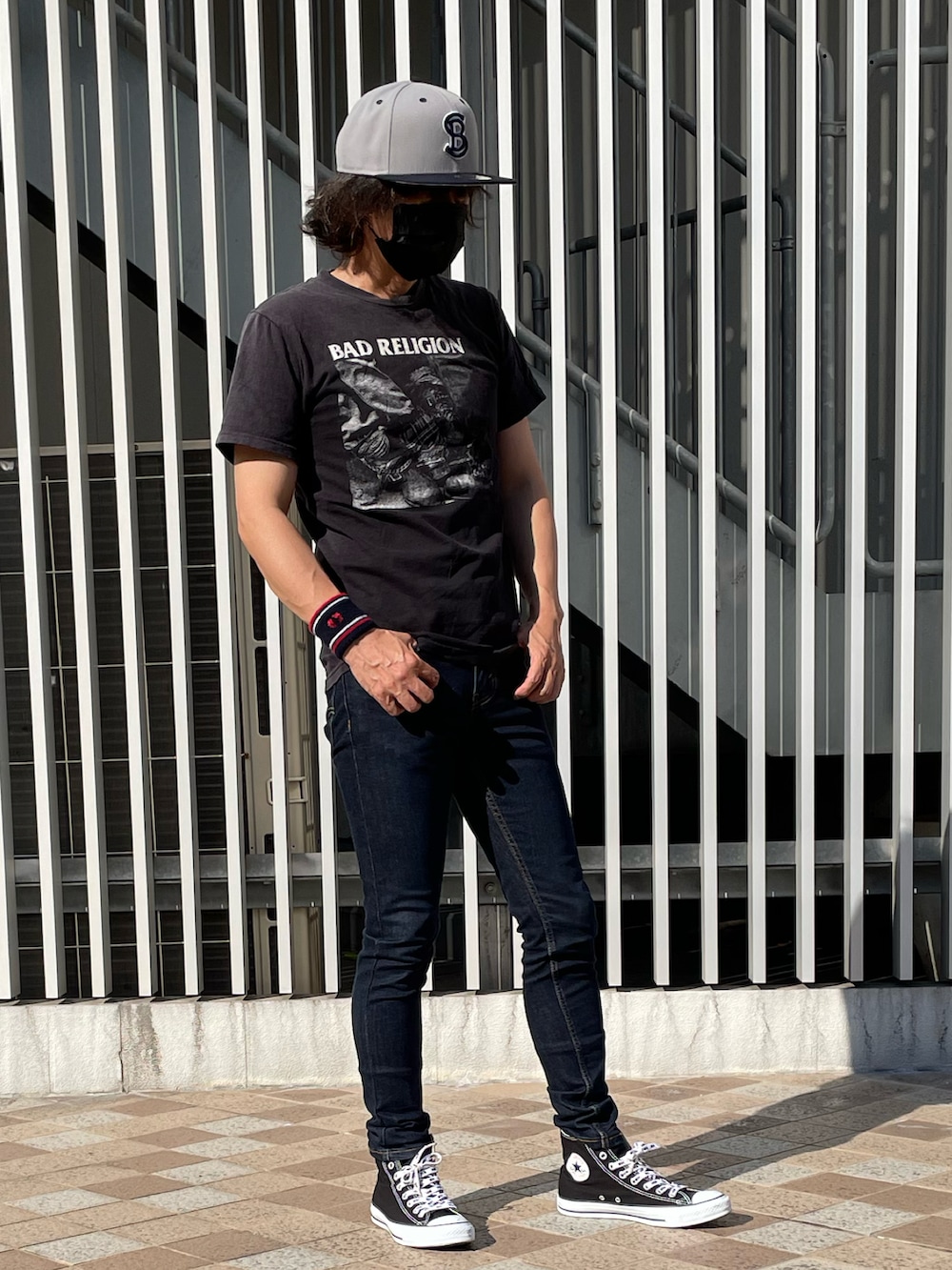 ブラック系のスニーカー、ブラック系のTシャツ/カットソー、ブルー系のデニムパンツを着用したメンズの夏コーディネートの2枚目の写真