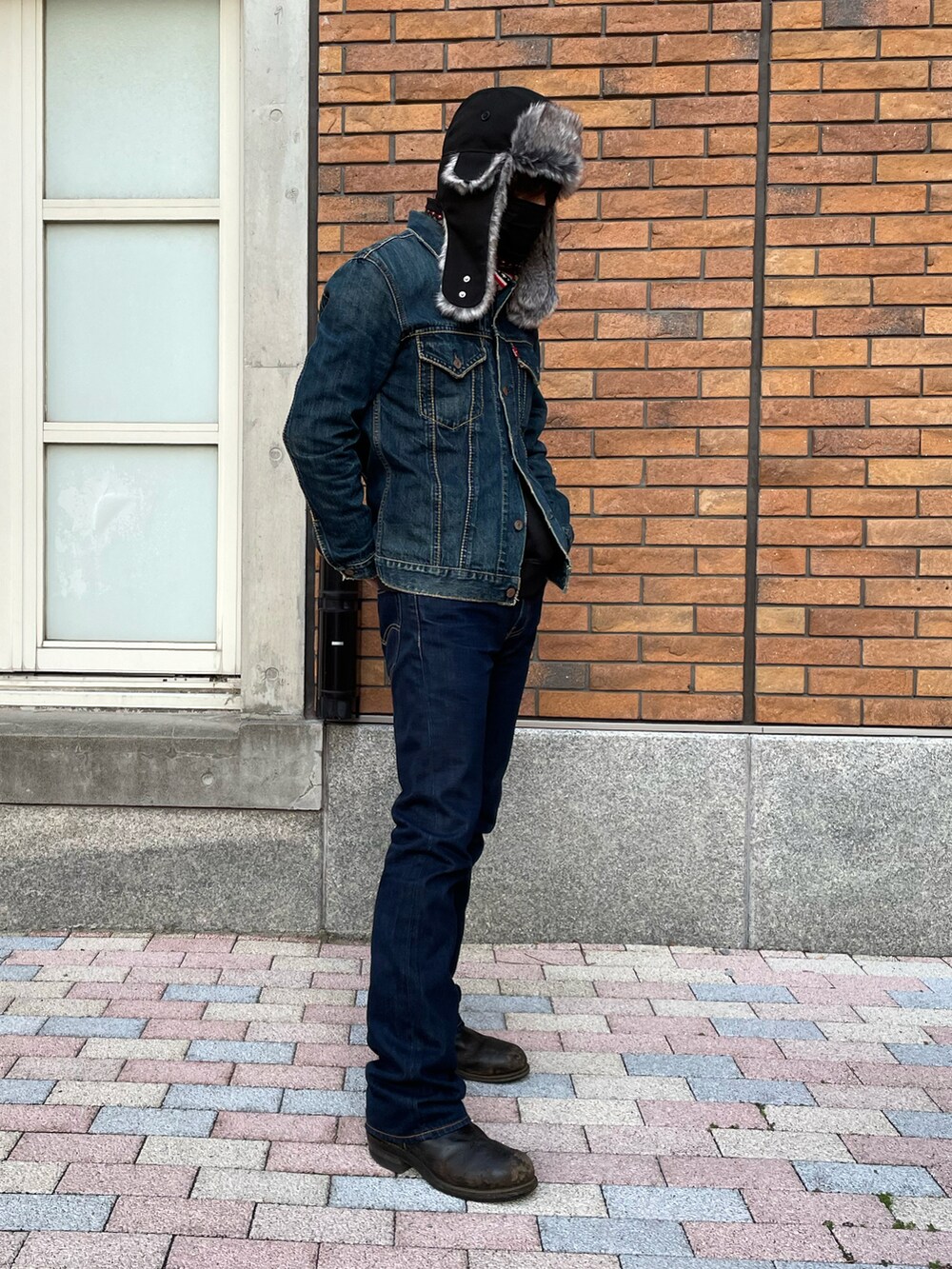 ブルー系のデニムパンツ、ブラック系のブーツ、ブラック系のスカジャンを着用したメンズの冬コーディネートの3枚目の写真
