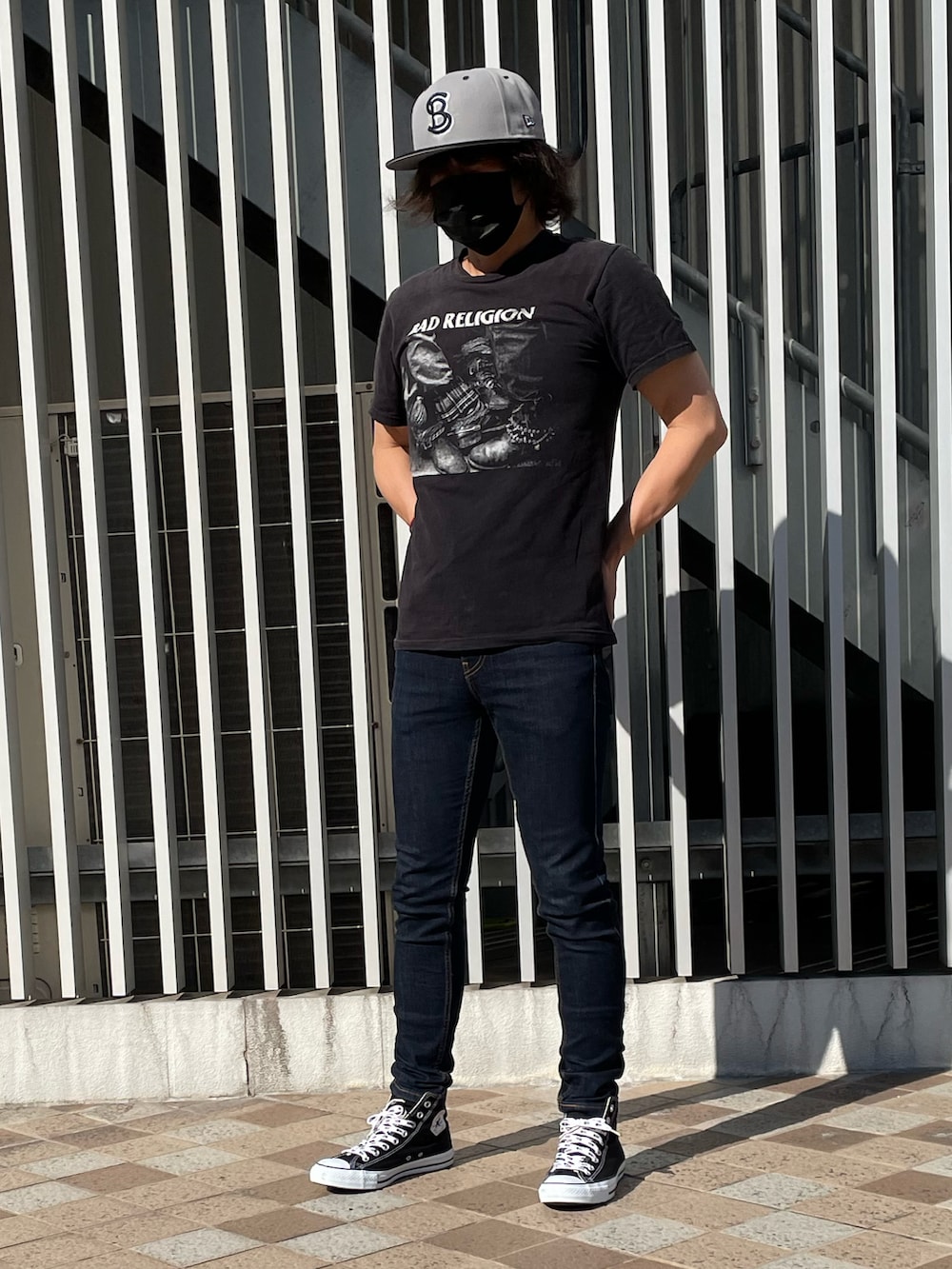 ブラック系のスニーカー、ブラック系のTシャツ/カットソー、ブルー系のデニムパンツを着用したメンズの夏コーディネートの5枚目の写真