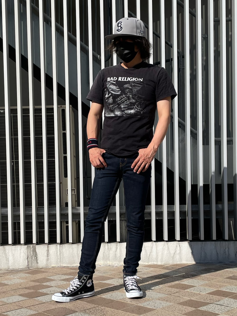 ブラック系のスニーカー、ブラック系のTシャツ/カットソー、ブルー系のデニムパンツを着用したメンズの夏コーディネートの3枚目の写真
