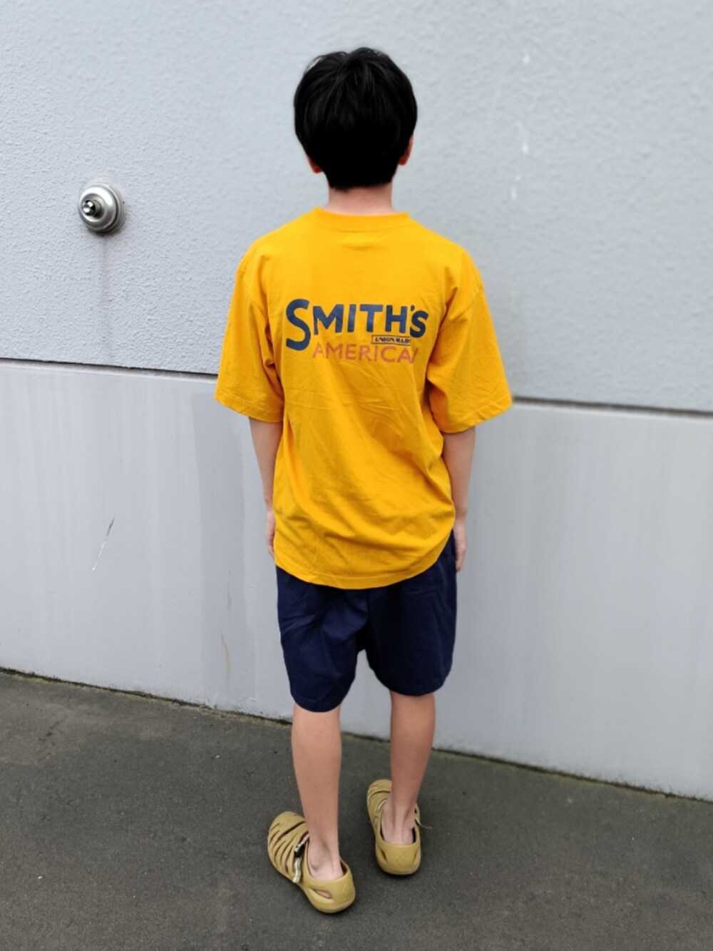 イエロー系のTシャツ/カットソー、ブルー系のチノパンツ、ベージュ系のサンダルを着用したキッズの夏コーディネートの2枚目の写真