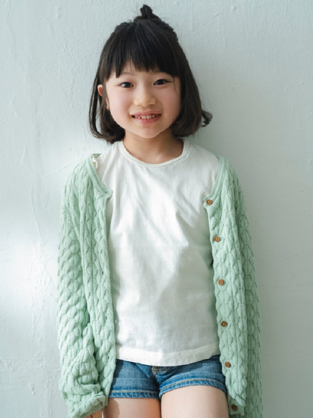 ホワイト系のTシャツ/カットソー、グリーン系のカーディガン/ボレロ、ブルー系のデニムパンツを着用したキッズの夏コーディネートの2枚目の写真