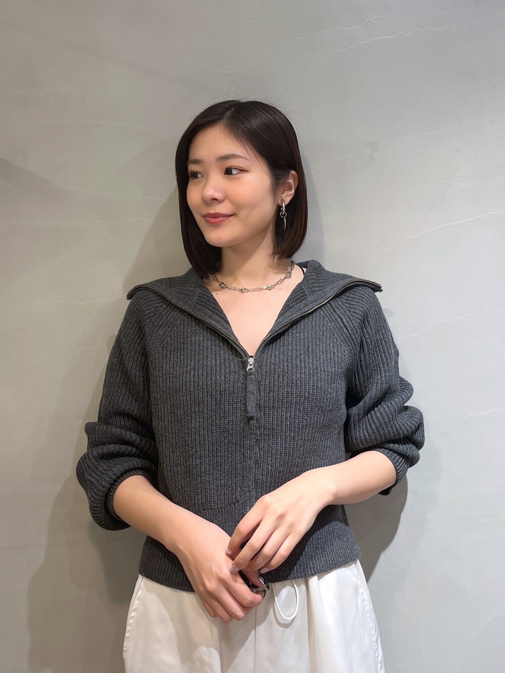 ホワイト系のカーゴパンツ、グレー系のカーディガン/ボレロ、シルバー系のネックレスを着用したレディースの秋コーディネートの5枚目の写真