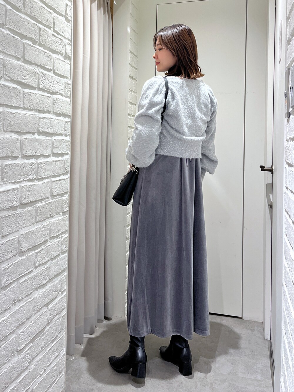 グレー系のワンピース、ブラック系のニット/セーター、グレー系のニット/セーターを着用したレディースの秋コーディネートの3枚目の写真