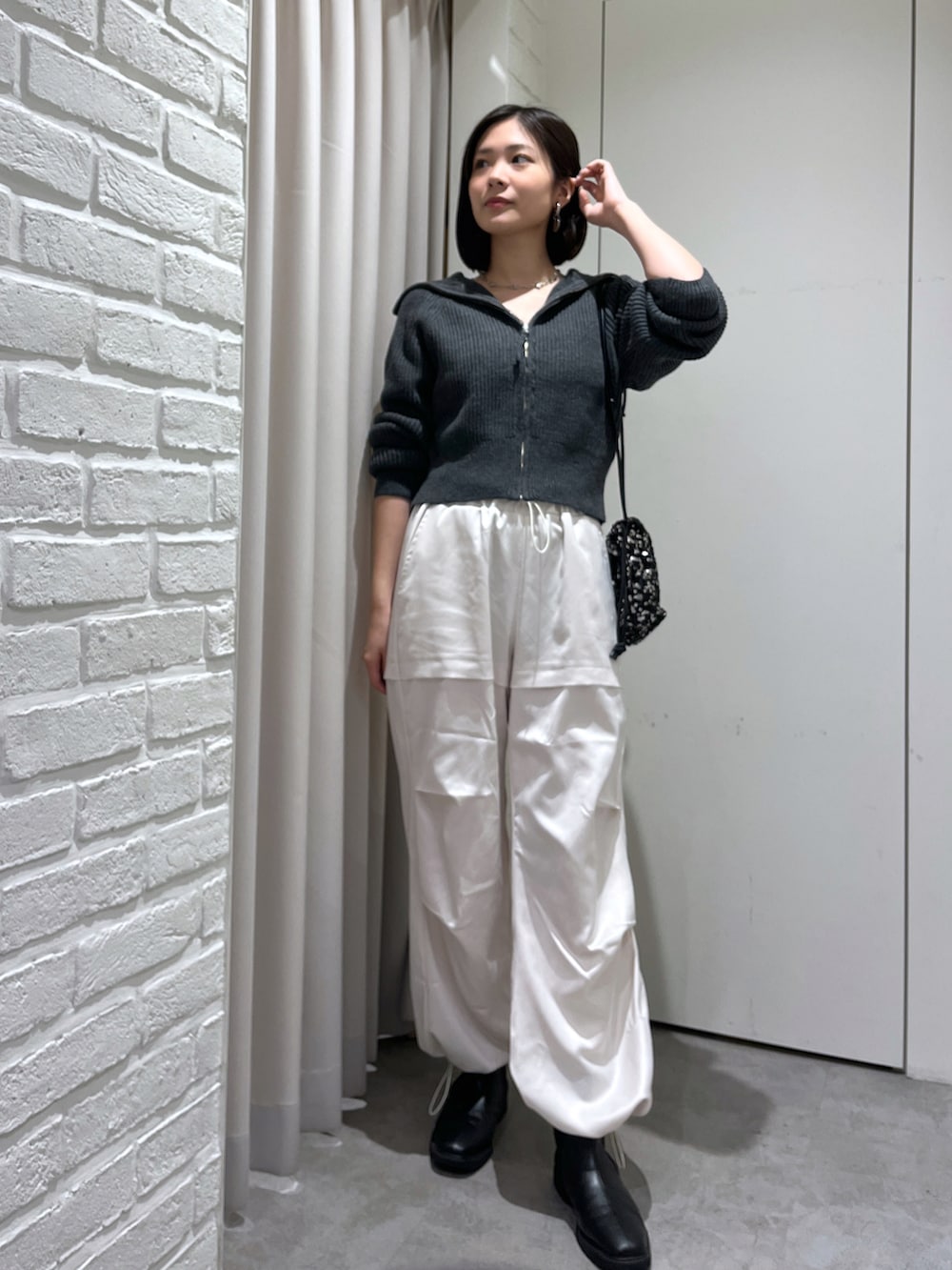 ホワイト系のカーゴパンツ、グレー系のカーディガン/ボレロ、シルバー系のネックレスを着用したレディースの秋コーディネートの2枚目の写真