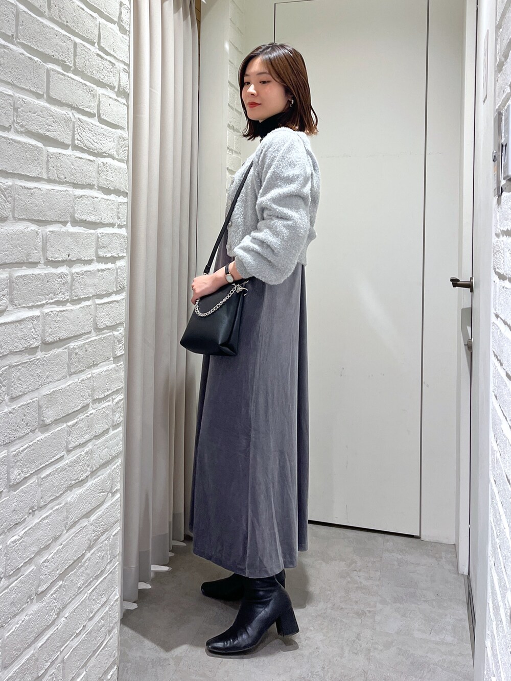 グレー系のワンピース、ブラック系のニット/セーター、グレー系のニット/セーターを着用したレディースの秋コーディネートの2枚目の写真
