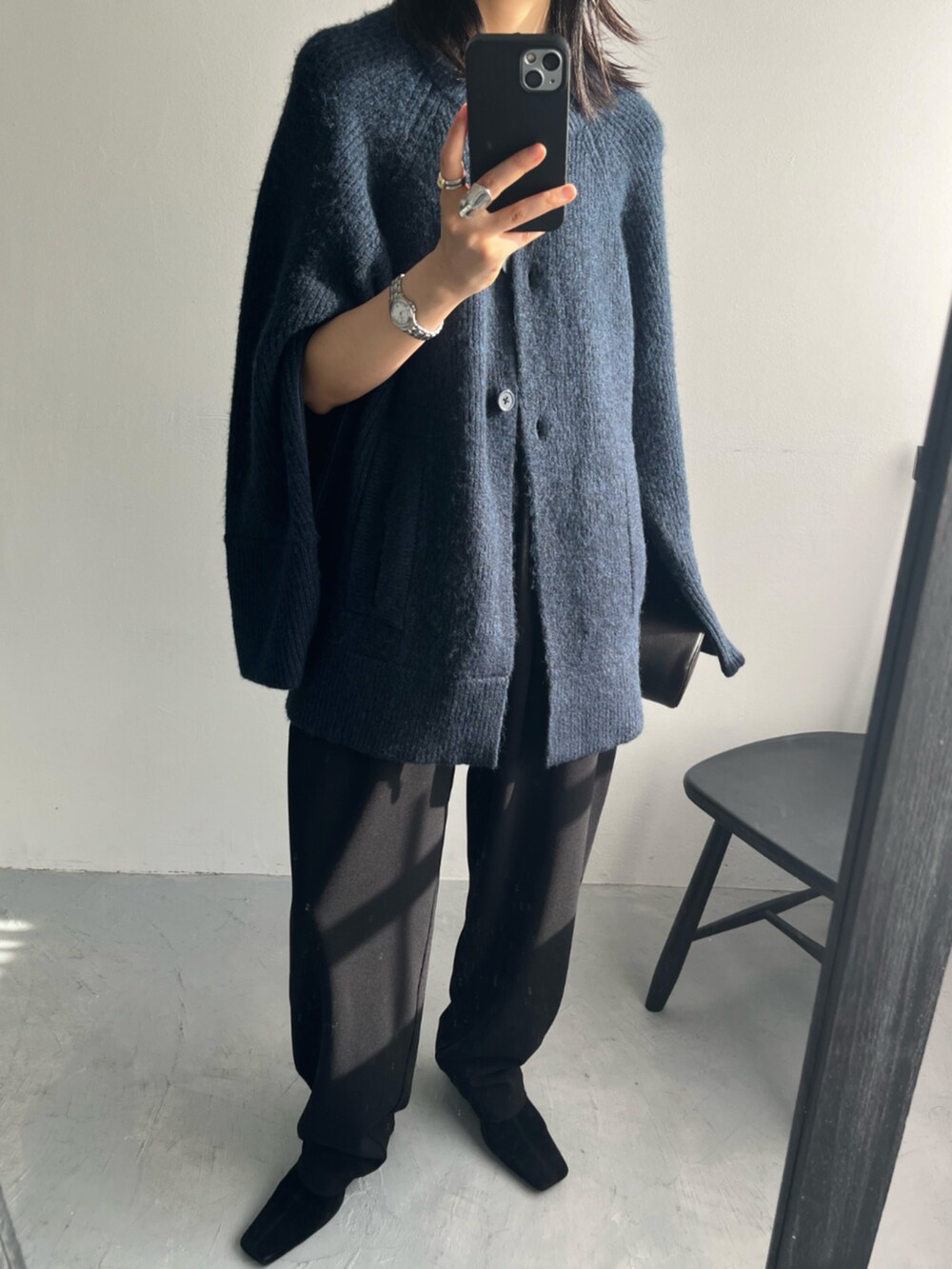 ブルー系のカーディガン/ボレロ、ブラウン系のクラッチバッグを着用したレディースの秋コーディネートの2枚目の写真