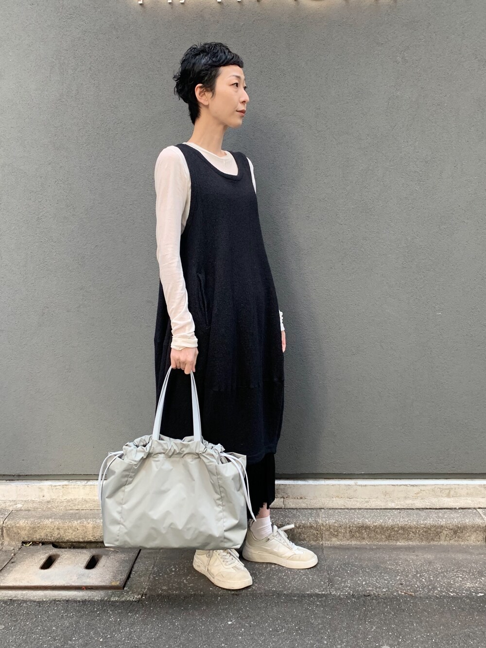 グリーン系のトートバッグを着用したレディースの春コーディネートの2枚目の写真