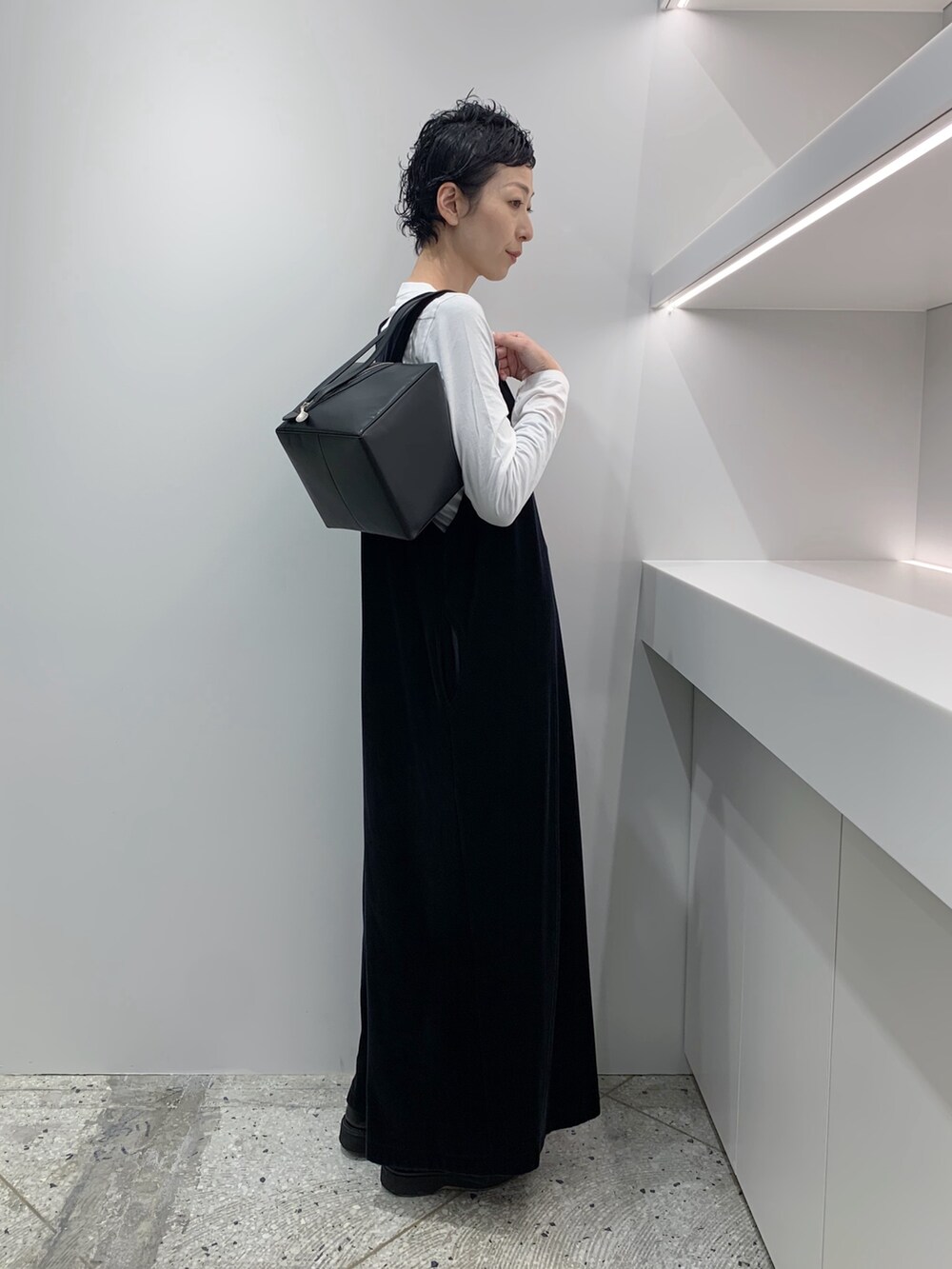 ブラック系のハンドバッグを着用したレディースの冬コーディネートの2枚目の写真