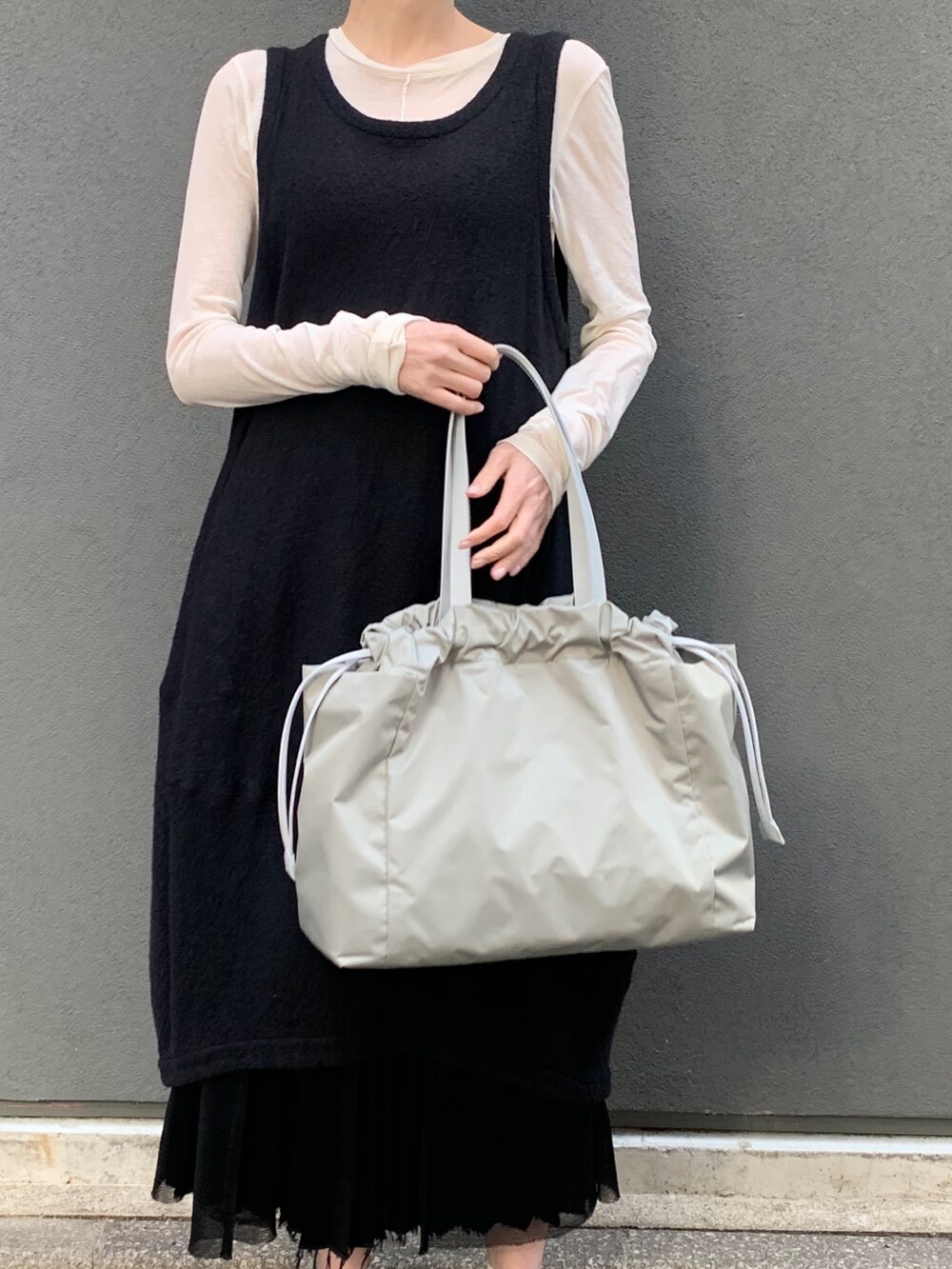 グリーン系のトートバッグを着用したレディースの春コーディネートの5枚目の写真