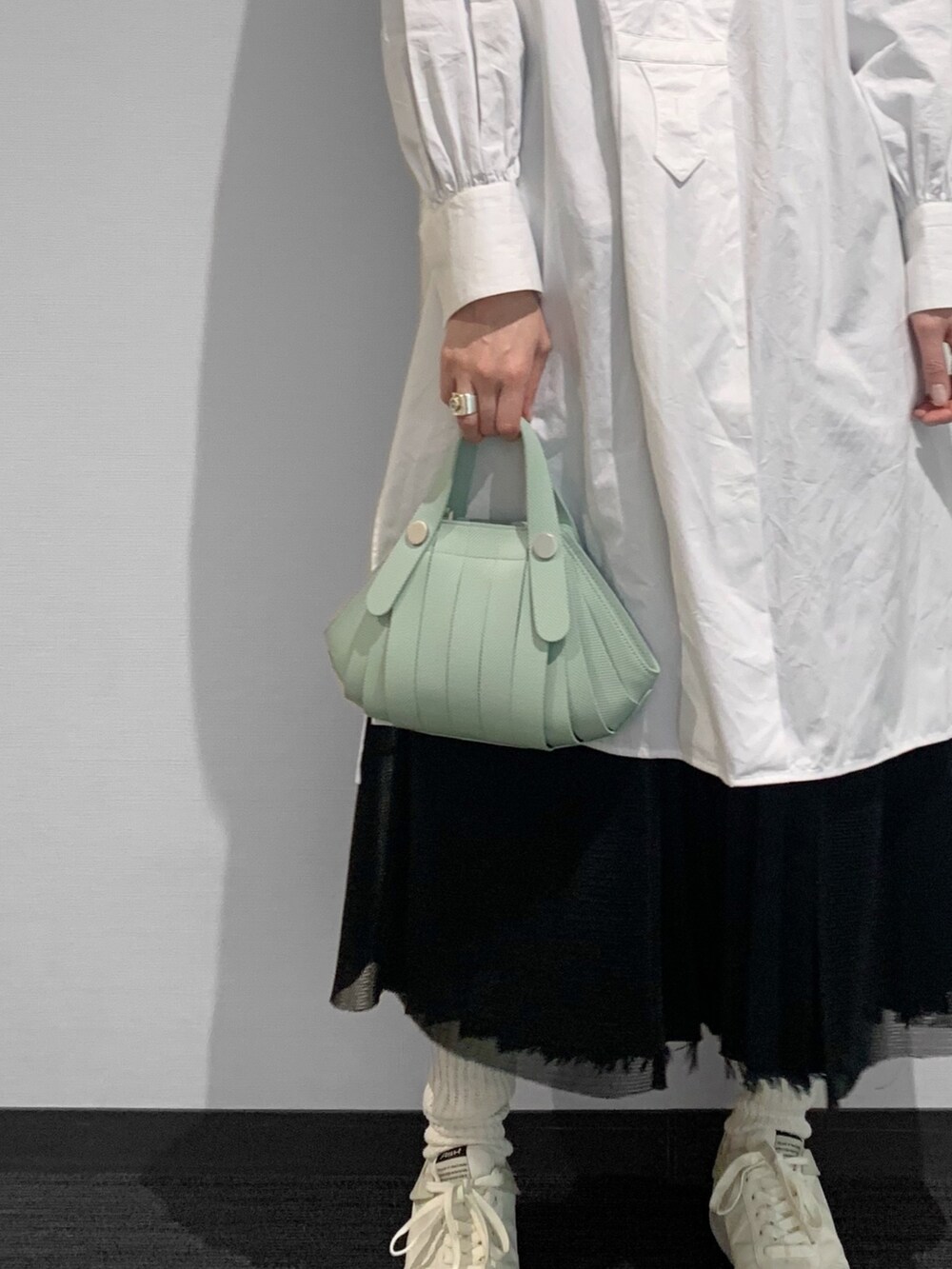 グリーン系のショルダーバッグを着用したレディースの春コーディネートの3枚目の写真