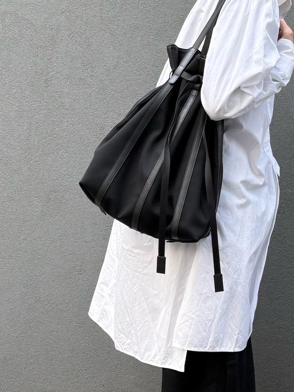 ブラック系のトートバッグを着用したレディースの冬コーディネートの2枚目の写真