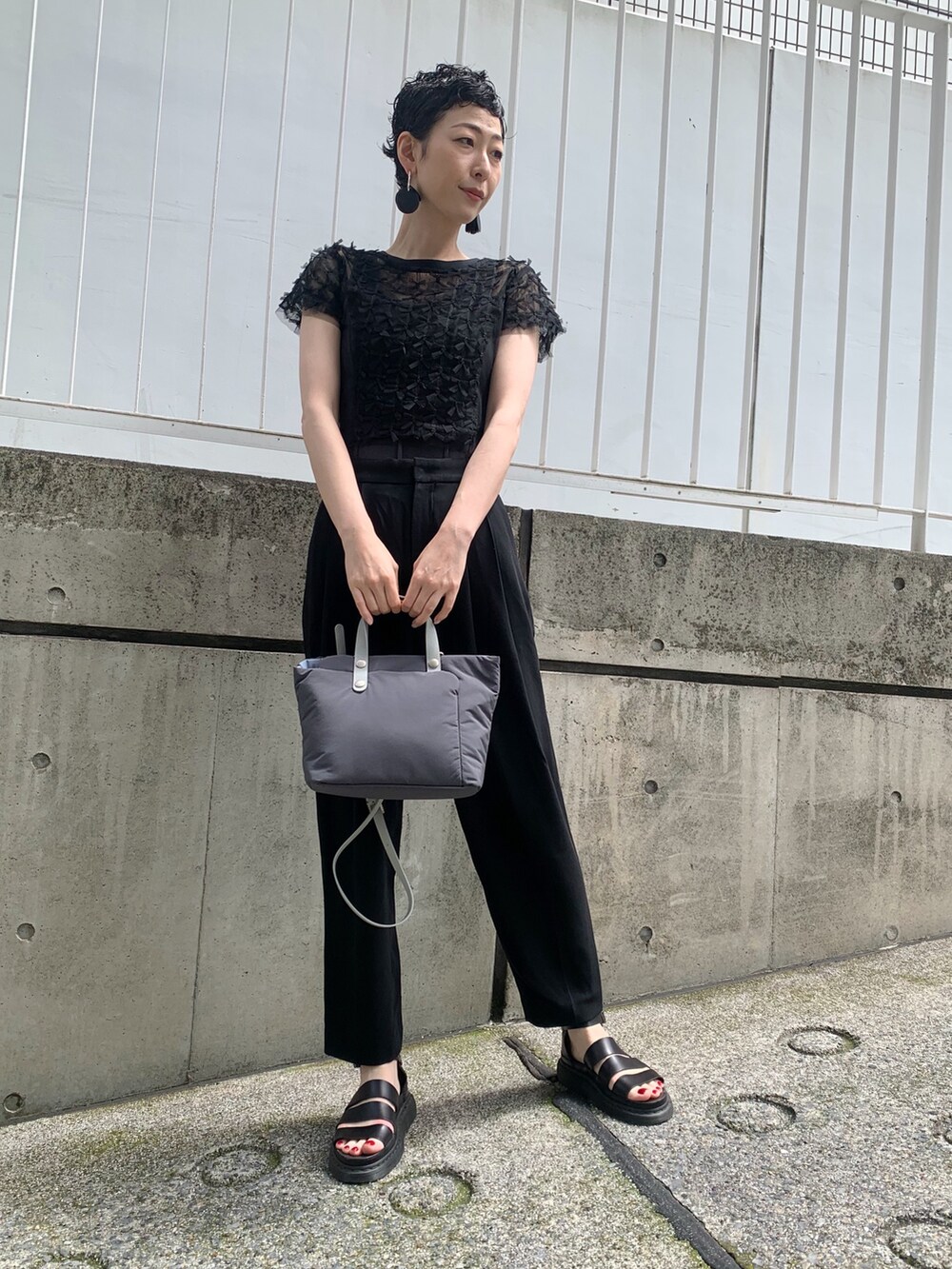 グレー系のショルダーバッグを着用したレディースの夏コーディネートの2枚目の写真
