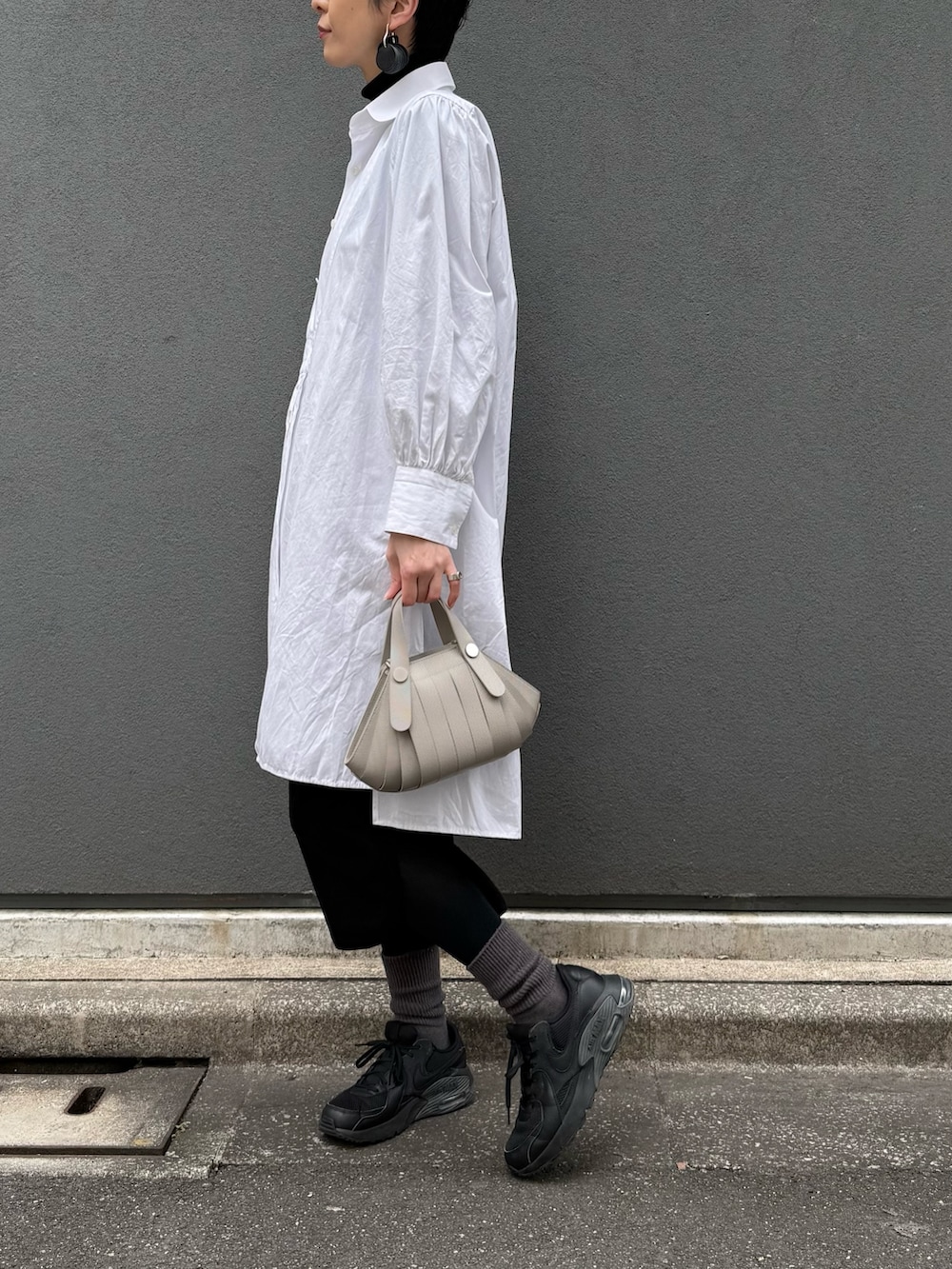 ベージュ系のショルダーバッグを着用したレディースの冬コーディネートの6枚目の写真