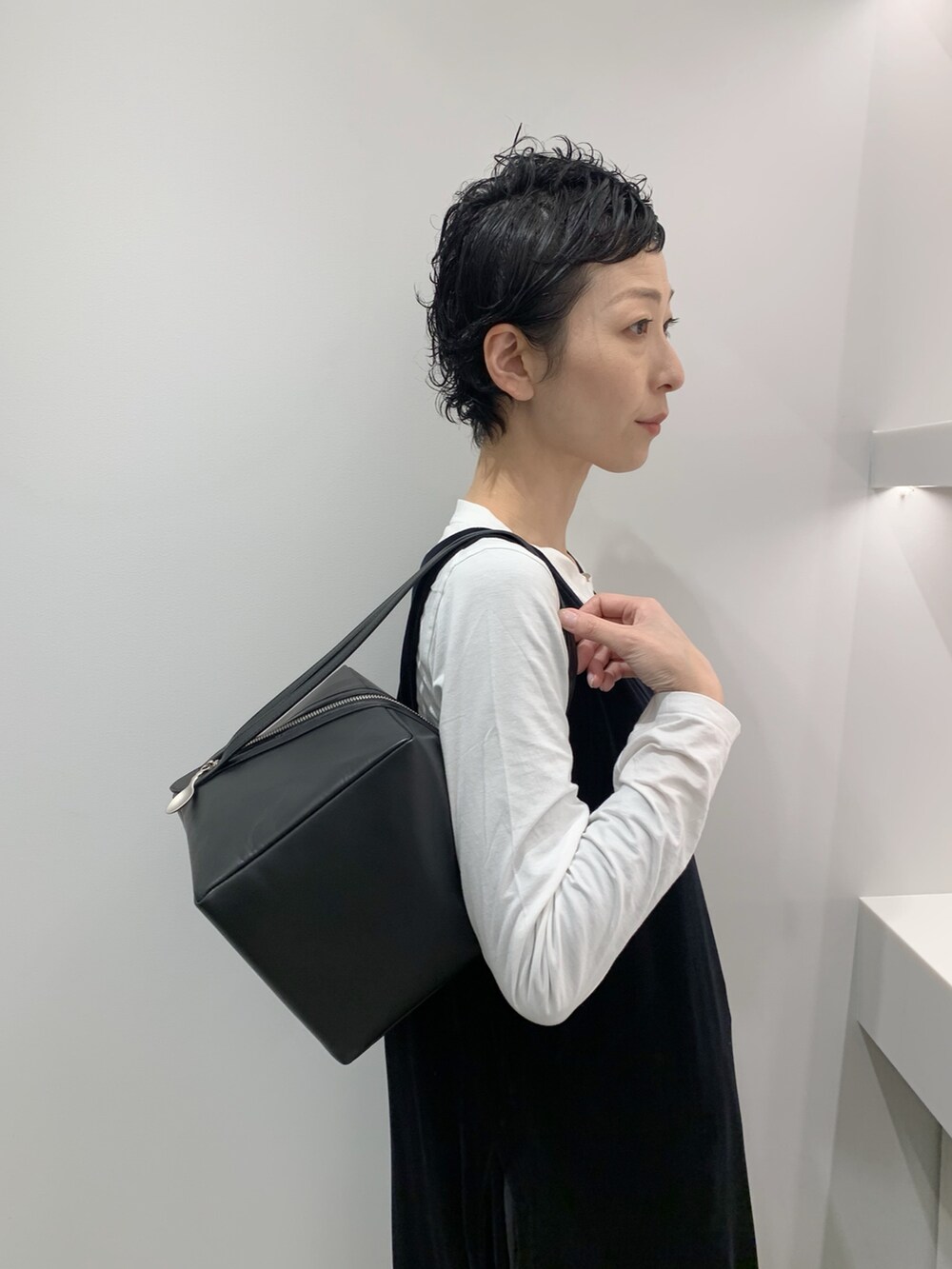 ブラック系のハンドバッグを着用したレディースの冬コーディネートの3枚目の写真