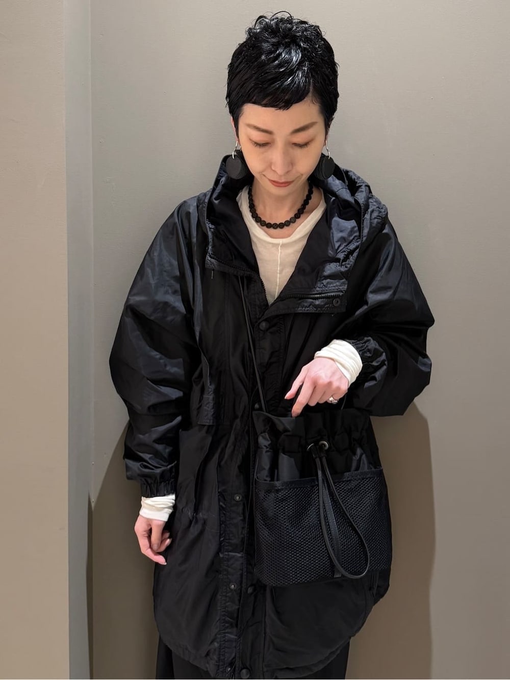 ブラック系のショルダーバッグを着用したレディースの春コーディネートの2枚目の写真