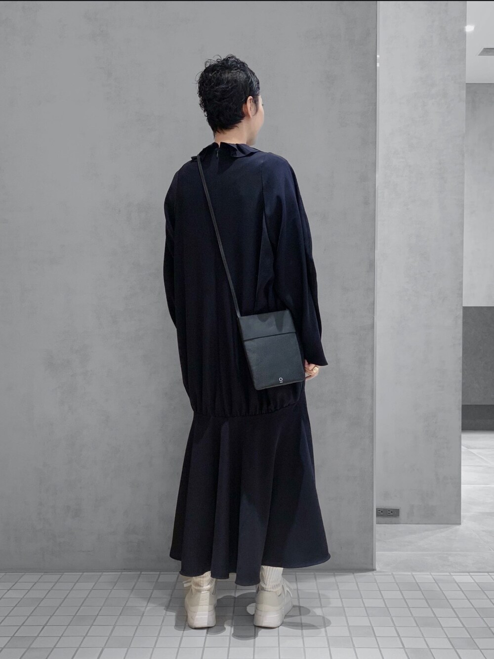 ブラック系のショルダーバッグを着用したレディースの冬コーディネートの2枚目の写真