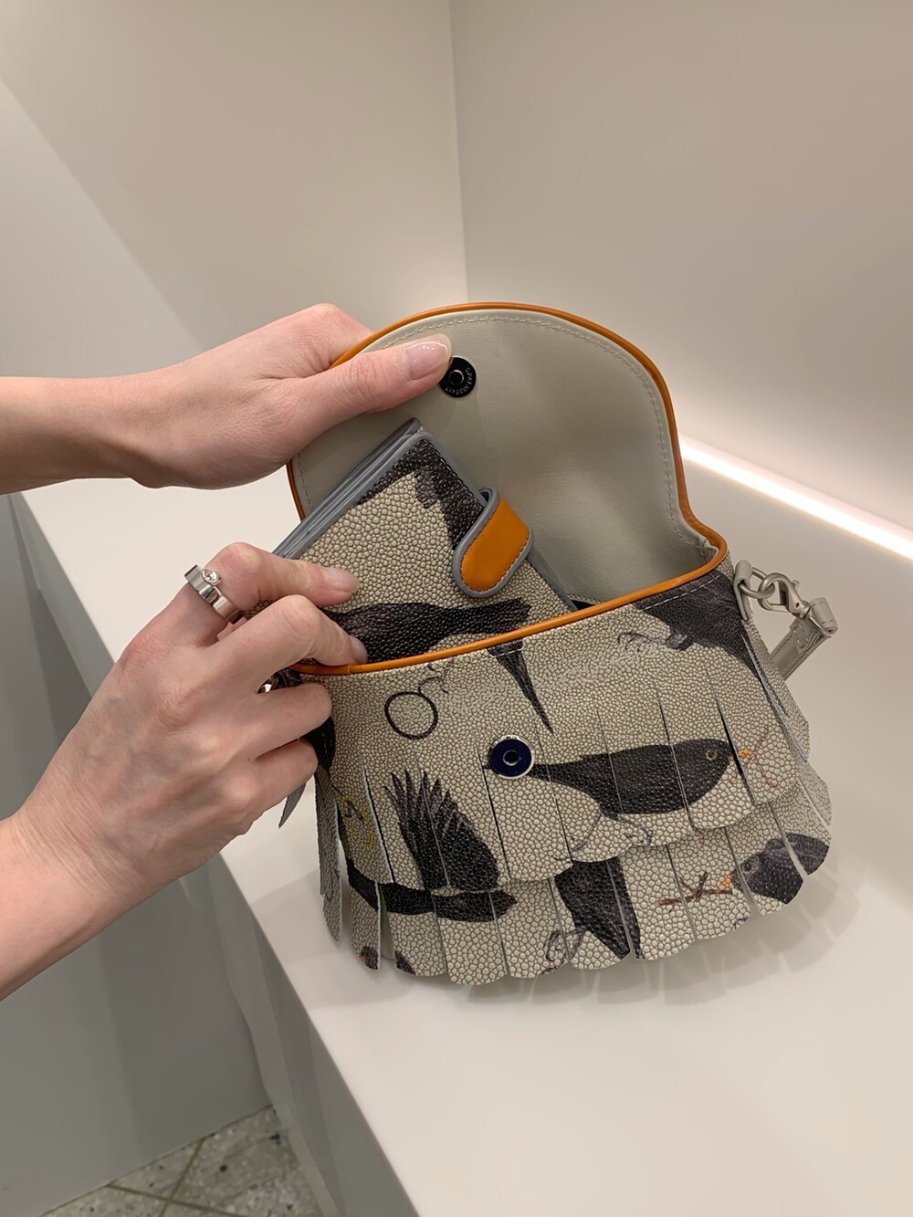 オレンジ系のショルダーバッグ、オレンジ系の財布を着用したレディースの春コーディネートの6枚目の写真