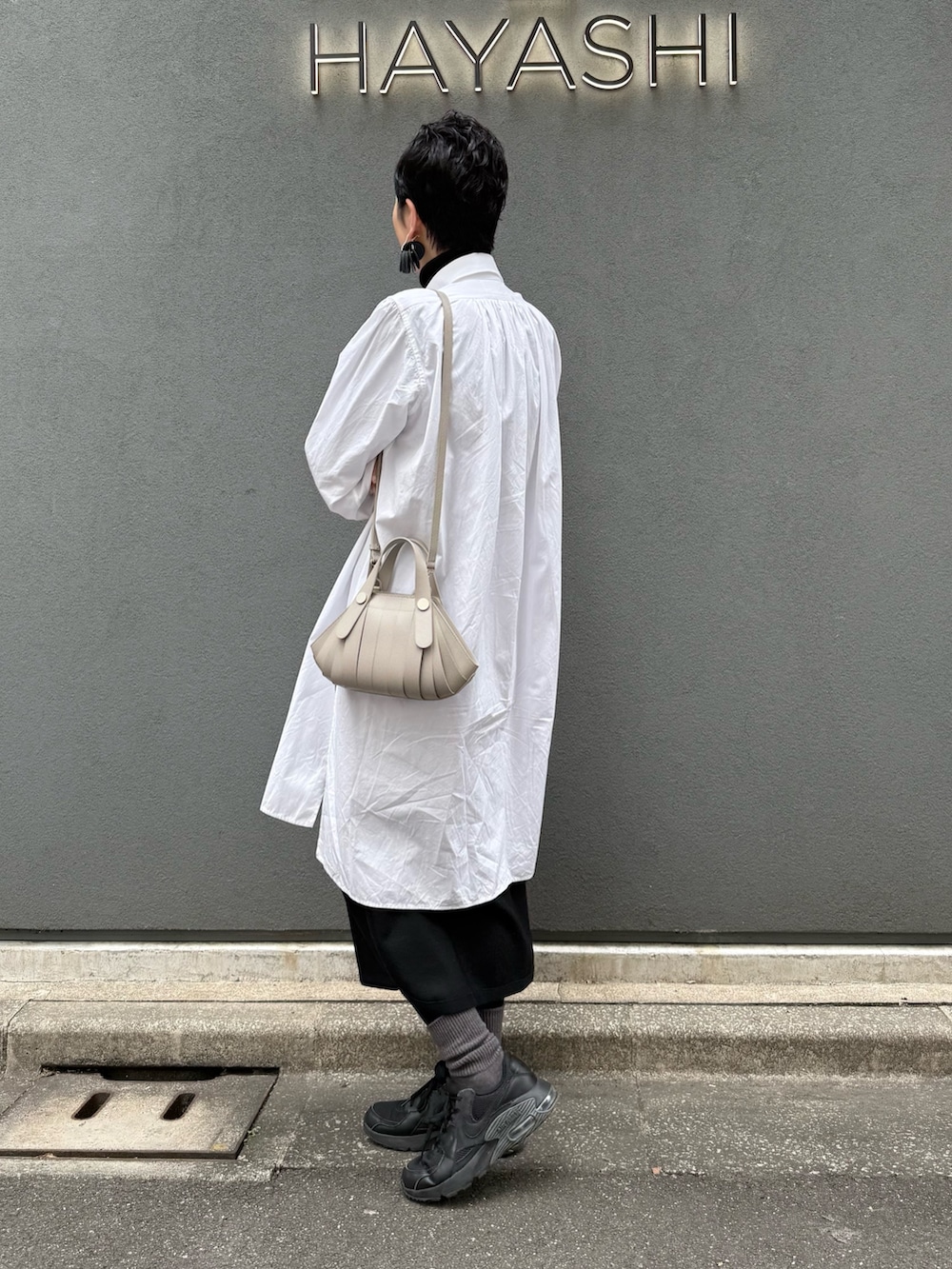 ベージュ系のショルダーバッグを着用したレディースの冬コーディネートの3枚目の写真