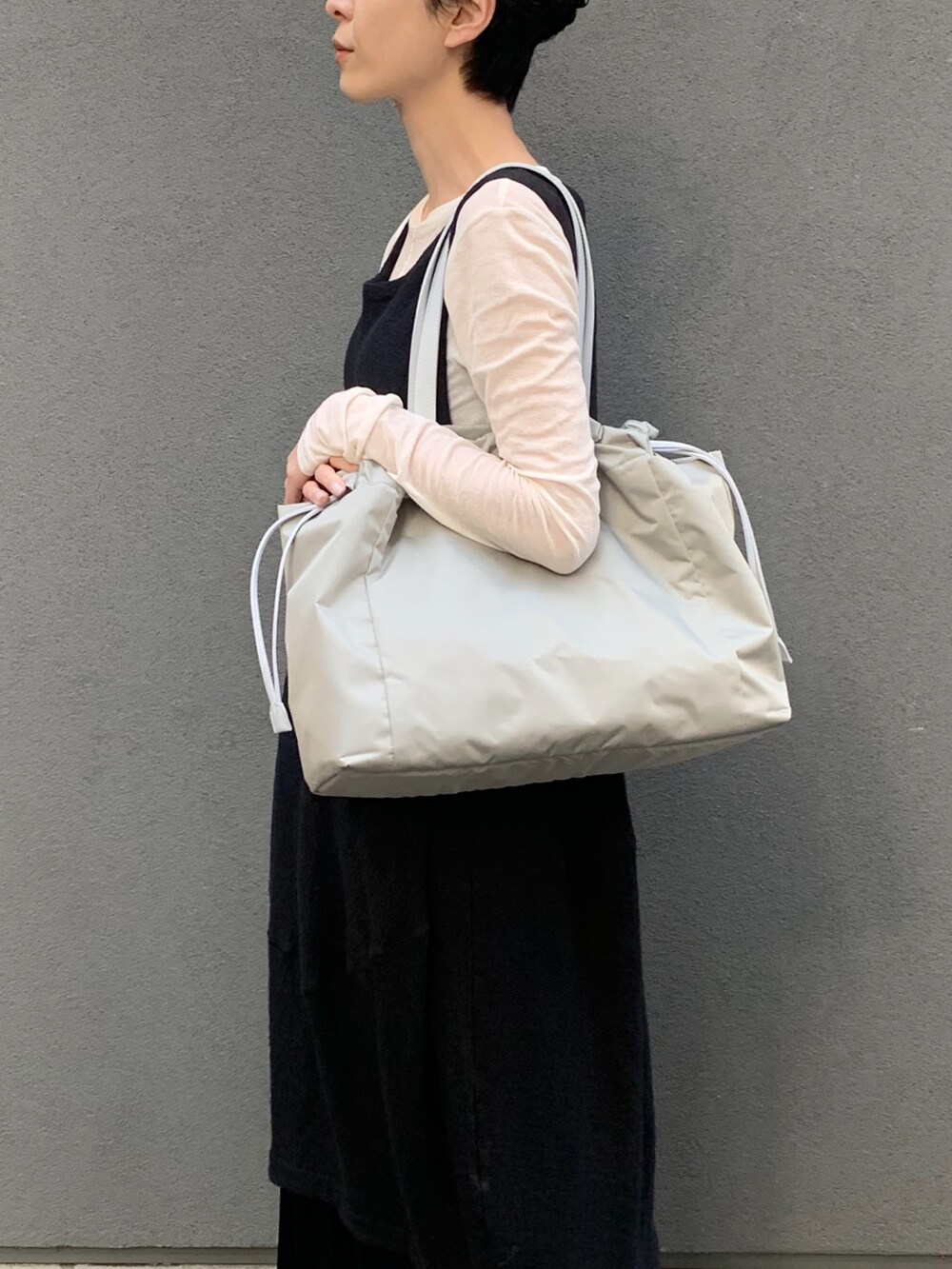 グリーン系のトートバッグを着用したレディースの春コーディネートの6枚目の写真