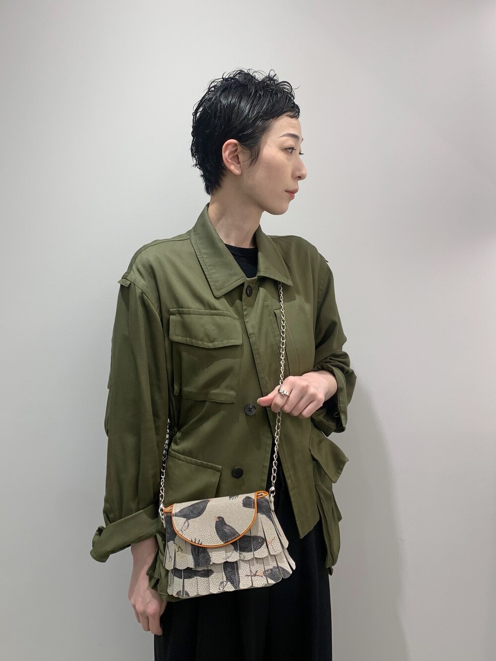 オレンジ系のショルダーバッグ、シルバー系のキーケース/キーアクセサリーを着用したレディースの春コーディネートの2枚目の写真