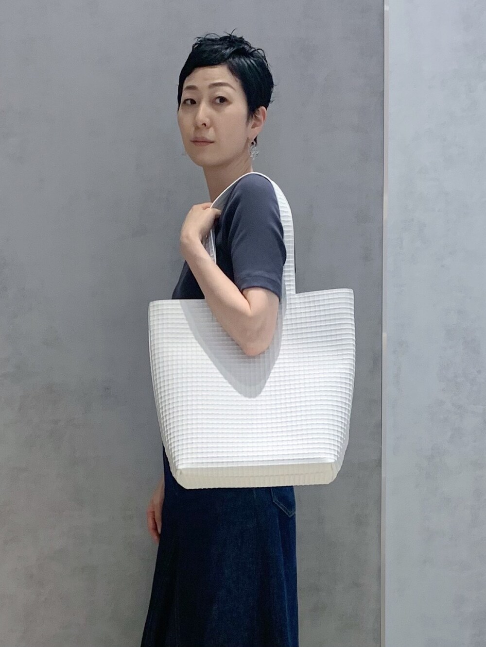 ホワイト系のトートバッグを着用したレディースの夏コーディネートの3枚目の写真