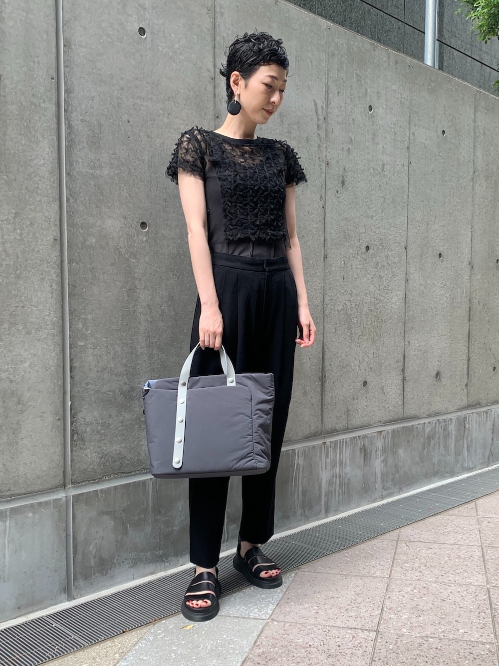 グレー系のトートバッグを着用したレディースの夏コーディネートの2枚目の写真