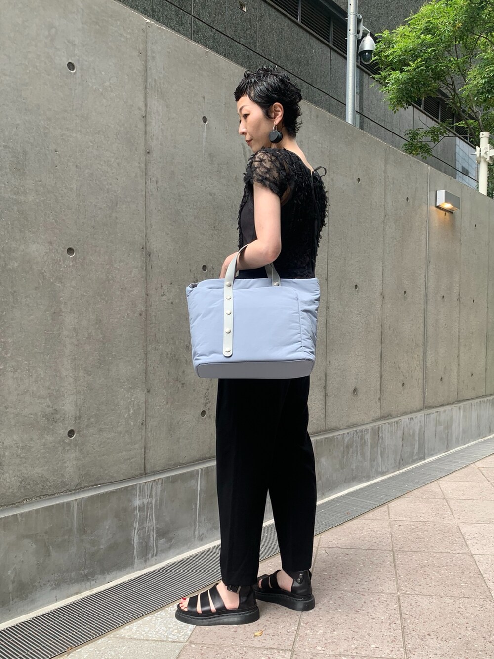 ブルー系のトートバッグを着用したレディースの夏コーディネートの3枚目の写真