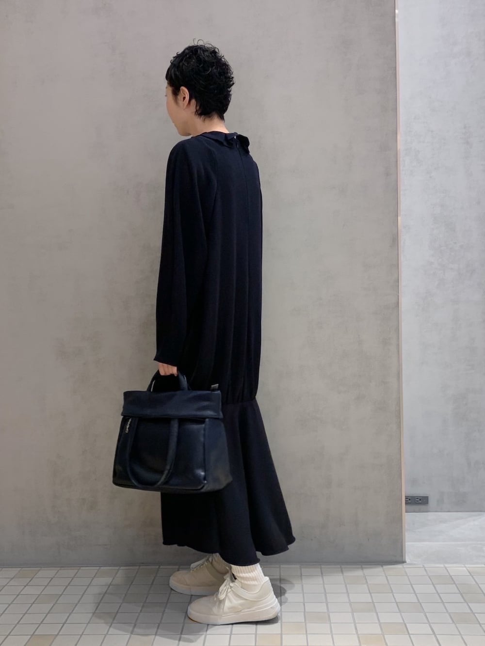 ブルー系のトートバッグを着用したレディースの夏コーディネートの2枚目の写真