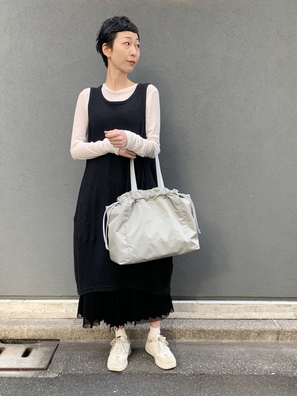 グリーン系のトートバッグを着用したレディースの春コーディネートの3枚目の写真