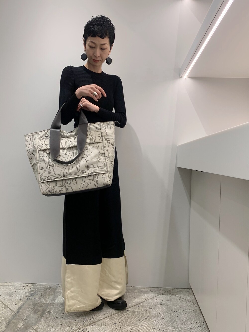 ベージュ系のボストンバッグを着用したレディースの秋コーディネートの2枚目の写真