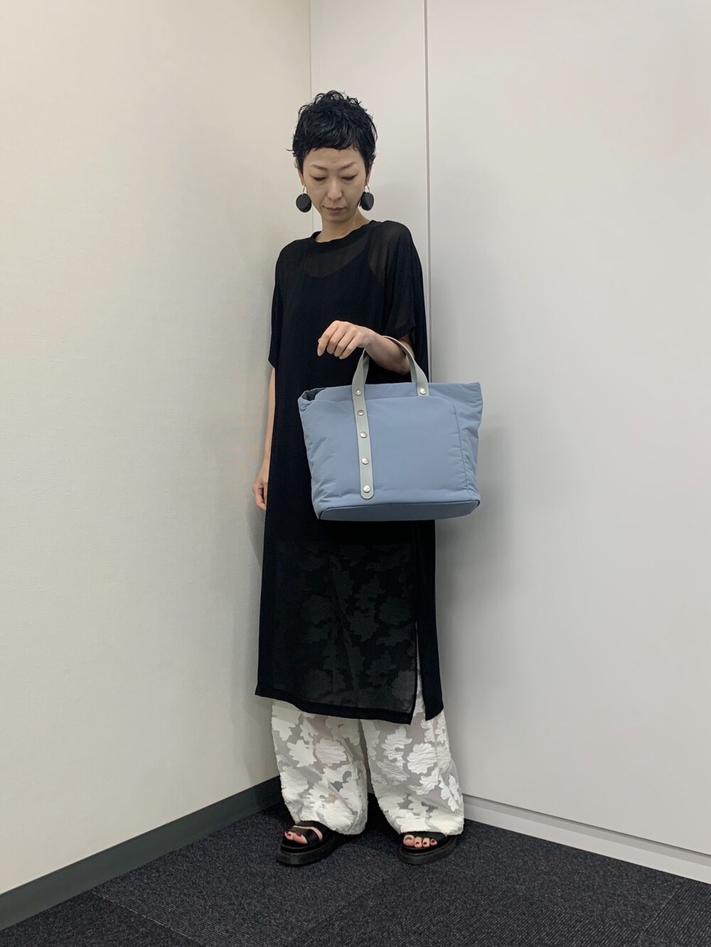 ブルー系のトートバッグを着用したレディースの夏コーディネートの2枚目の写真