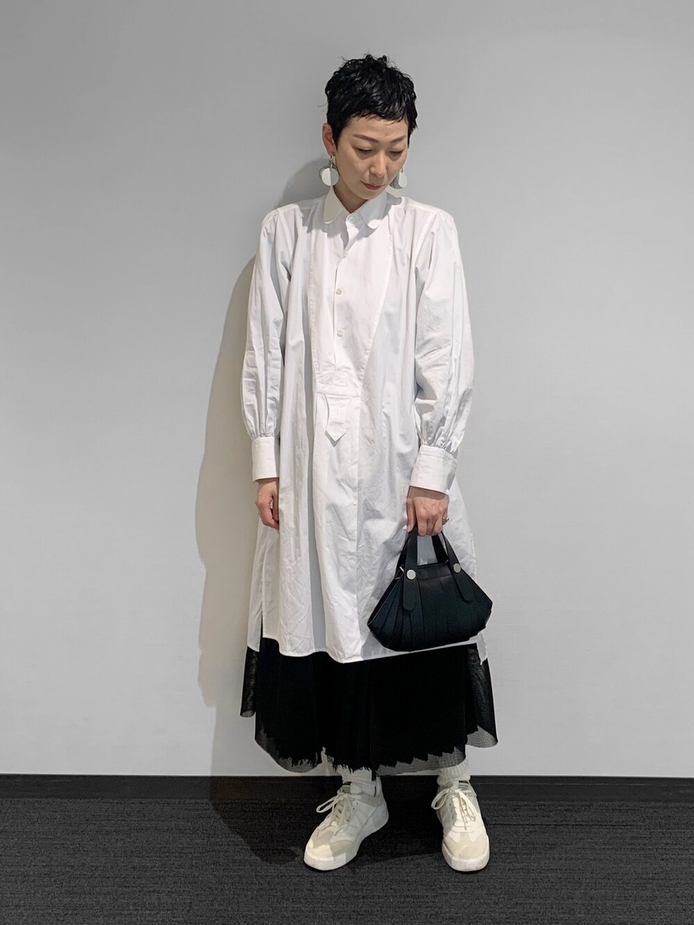 ブラック系のショルダーバッグを着用したレディースの春コーディネートの2枚目の写真